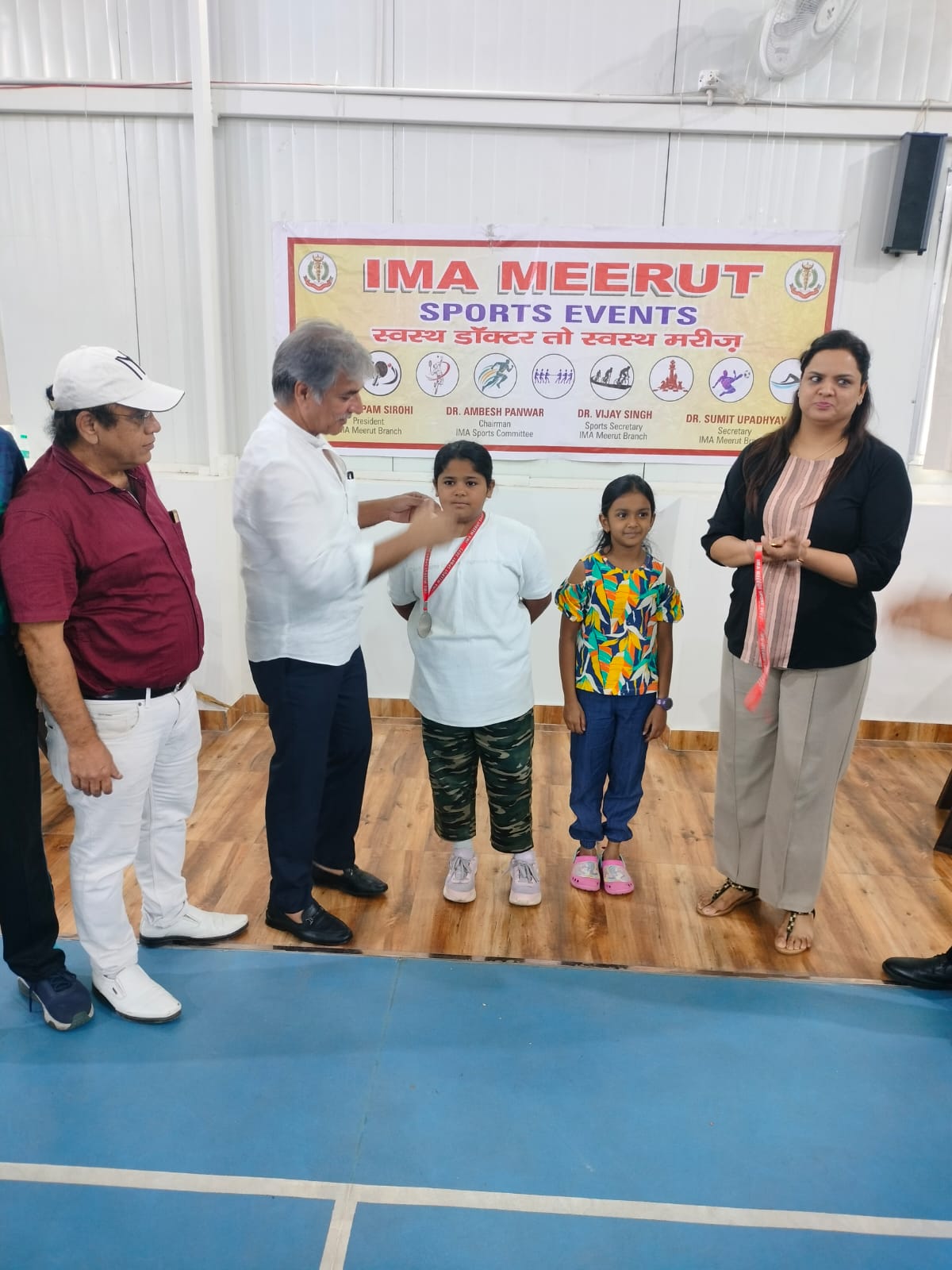 विजेता बच्चों को मेडल पहनाते डॉक्टर्स