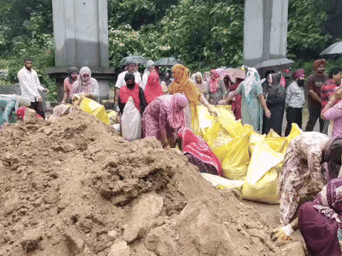 रूपनगर क्षेत्र में नहर में मिट्ट खिसकने से धुस्सी बांध टूटने का खतरा बढ़ गया है। इसी बीच बचाव कार्य में जुटी महिलाएं।