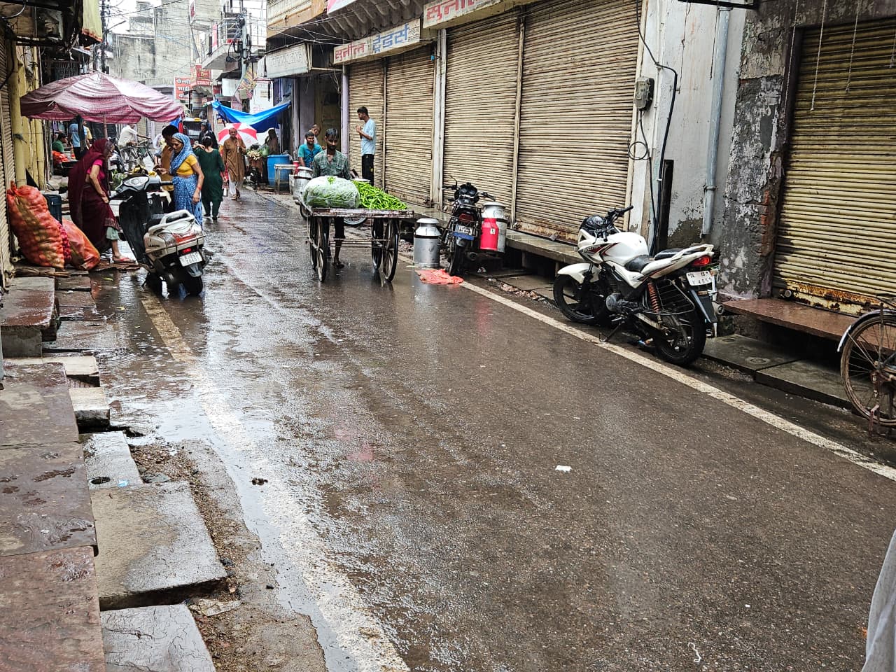 लोग अपने घरों से बाहर छाता लेकर निकल रहे हैं।