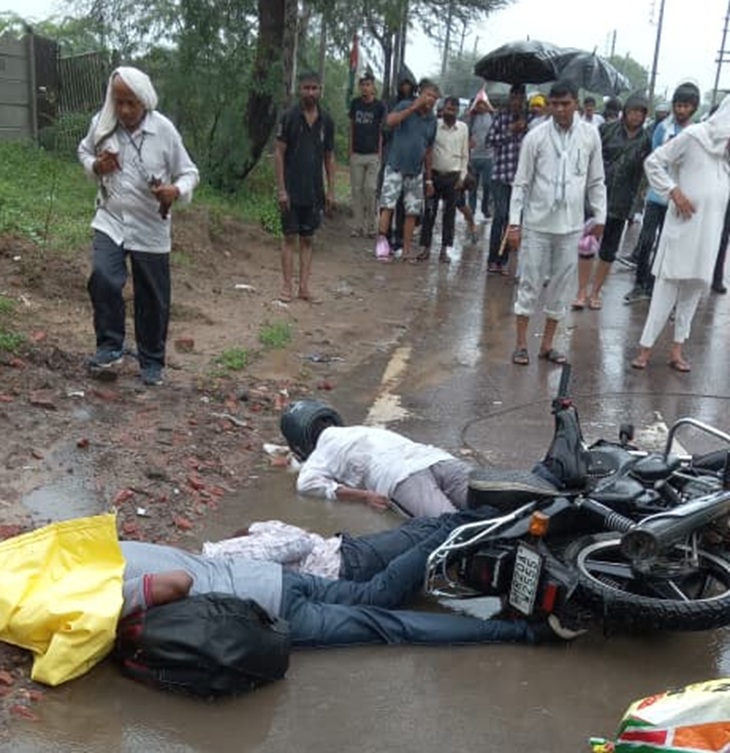 People standing near the bodies of youths lying on the road on Mirzapur road.