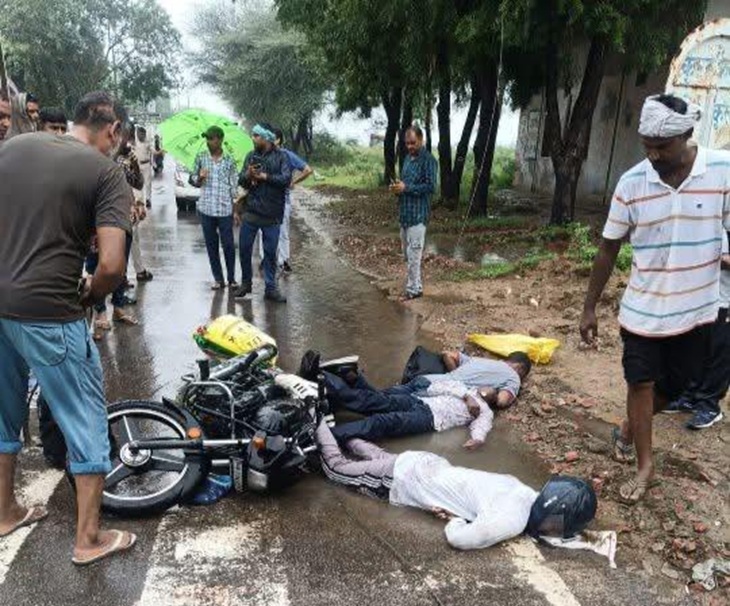 मिर्जापुर रोड पर सड़क पर पड़े युवकों के शव के पास खड़े लोग।