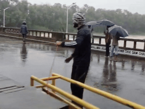 People present on the bridge after the water level in Sukhna Cho rises.