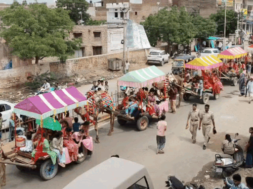 शोभायात्रा में ऊट गाड़ी पर भजन कीर्तन करते हुए महिलाएं।
