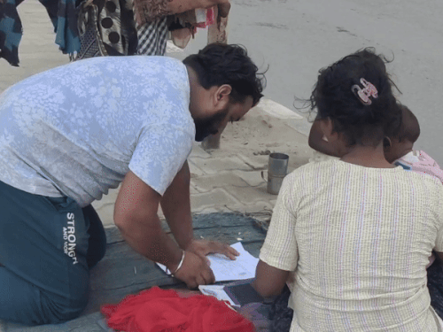 बच्ची की मौत के बाद महिला से दस्तावेजों पर अंगूठे लगवाता दुकानदार।