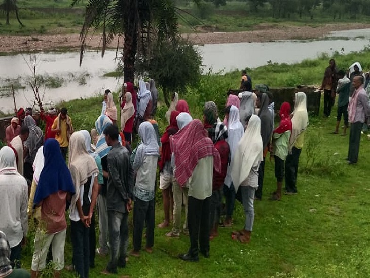 झाड़ोल के वेलनिया गांव में अंतिम संस्कार के दौरान बारिश से भीगते ग्रामीण।