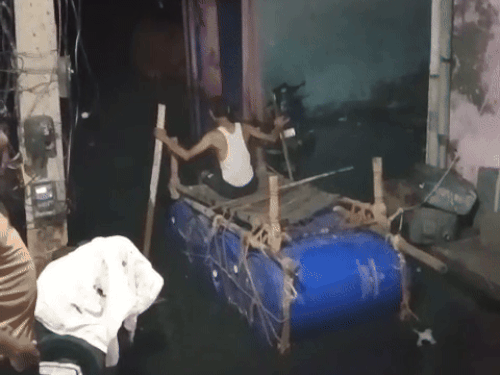 प्लास्टिक के ड्रम पर चारपाई बांधकर लोगों ने नाव बनाई है।