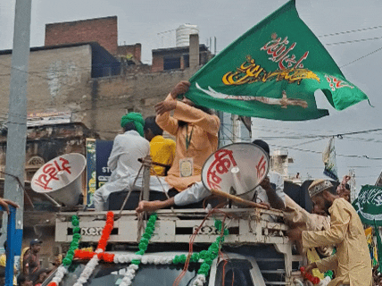 मुस्लिम समाज का झंडा फहराता युवक।