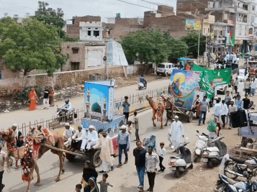 जुलूस में ऊंट गाड़ी पर सजी झांकियां।