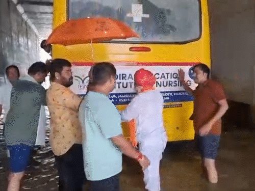 उदयपुर ग्रामीण से भाजपा विधायक फूल सिंह मीणा पानी में फंसी बस को धक्का लगाते हुए।