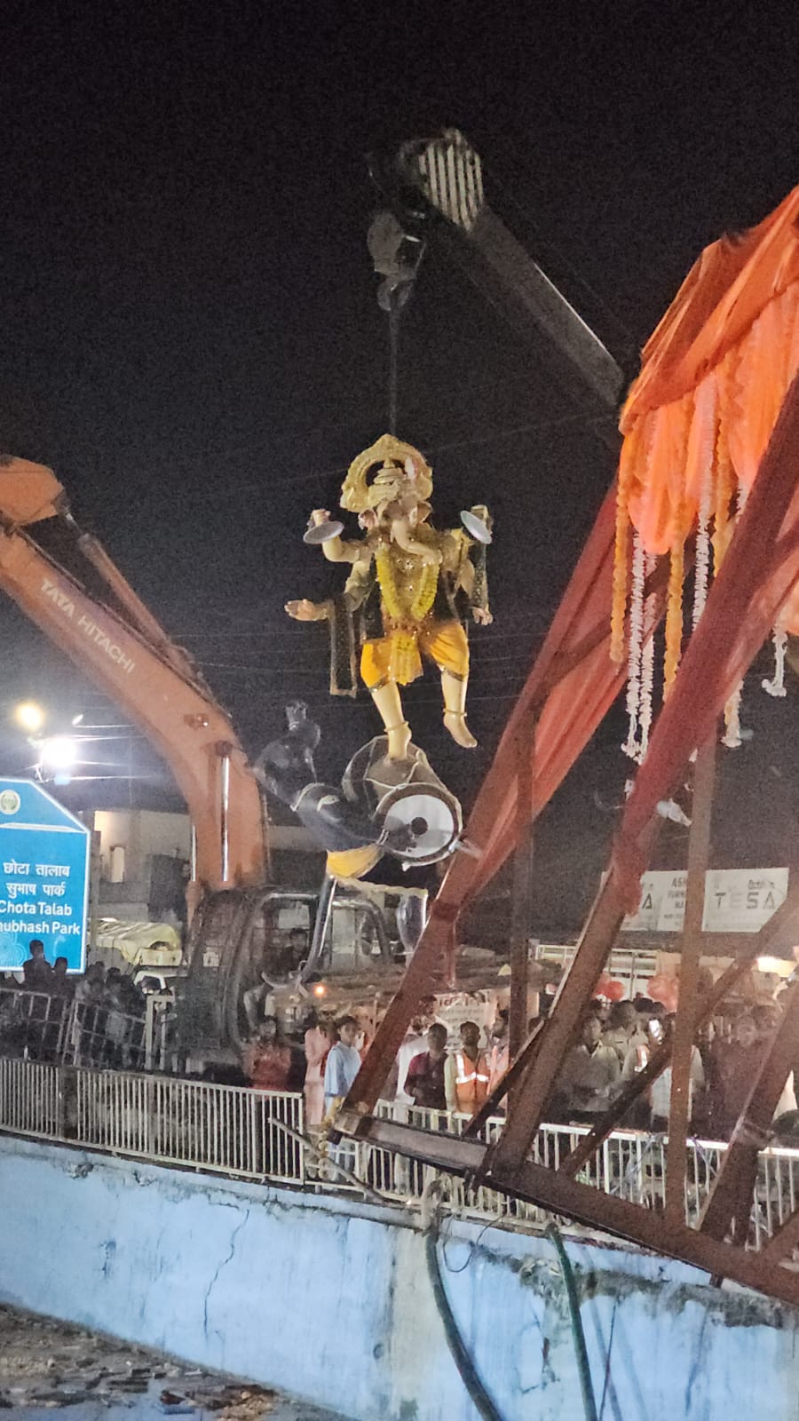 क्रेन के जरिए विसर्जित होती प्रतिमा