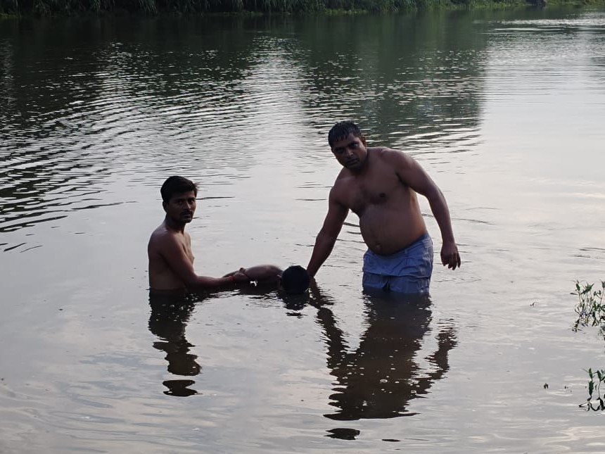 नदी से शव निकालते ग्रामीण।