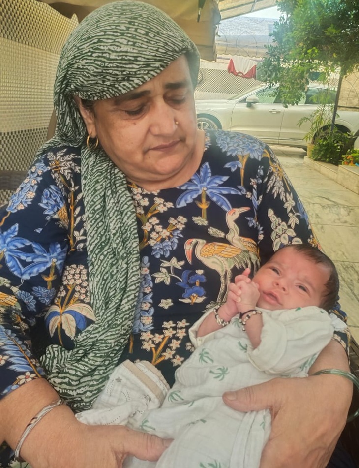 विनेश फोगाट के बेटे कृधव को गोद में लेकर बैठीं सोमवीर राठी की मां।