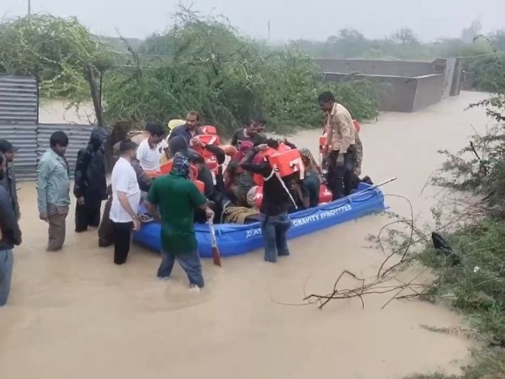 एनडीआरएफ की टीमें बाढ़ में फंस लोगों को निकालती हुईं।