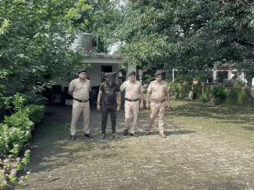 आरोपी को ले जाती पुलिस।