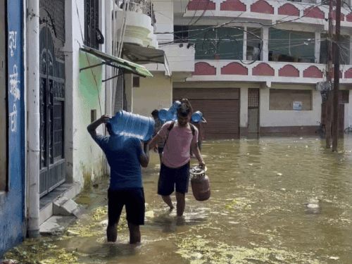 छात्रों को बाढ़ के पानी से होकर जाना पड़ रहा है।