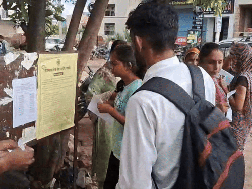 सेंटर के बाहर लगे सूचना पट्‌ट पर अपने रोल नम्बर व कक्ष की जानकारी लेते कैंडिडेट्स।