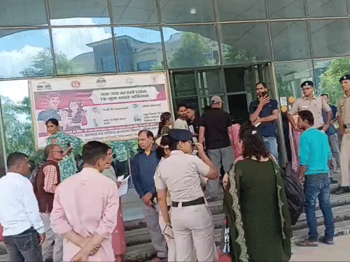 बम से उड़ाने की धमकी के बाद नेरचौक मेडिकल कॉलेज से बाहर आते हुए मरीज और तीमारदार।