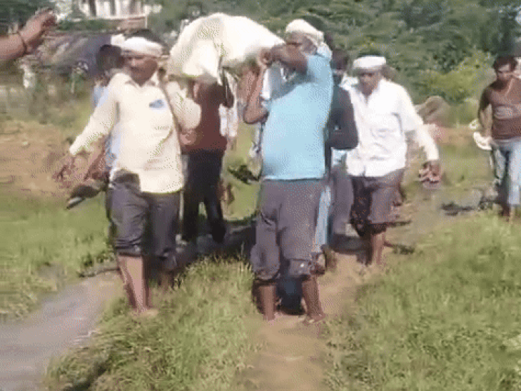 श्मशान घाट के रास्ते में भरे हुए पानी से अर्थी निकालते वाल्मीकि समाज के लोग। - Dainik Bhaskar