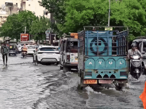 सूचना केन्द्र से आगरा गेट के बीच सड़क पर बहते पानी से गुजरते वाहन।