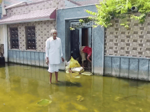 शिव बाड़ी रोड पर पानी घर के अंदर ना जाए, इसलिए बुजुर्ग ने गेट पर मिट्टी के कट्टे रख दिए।