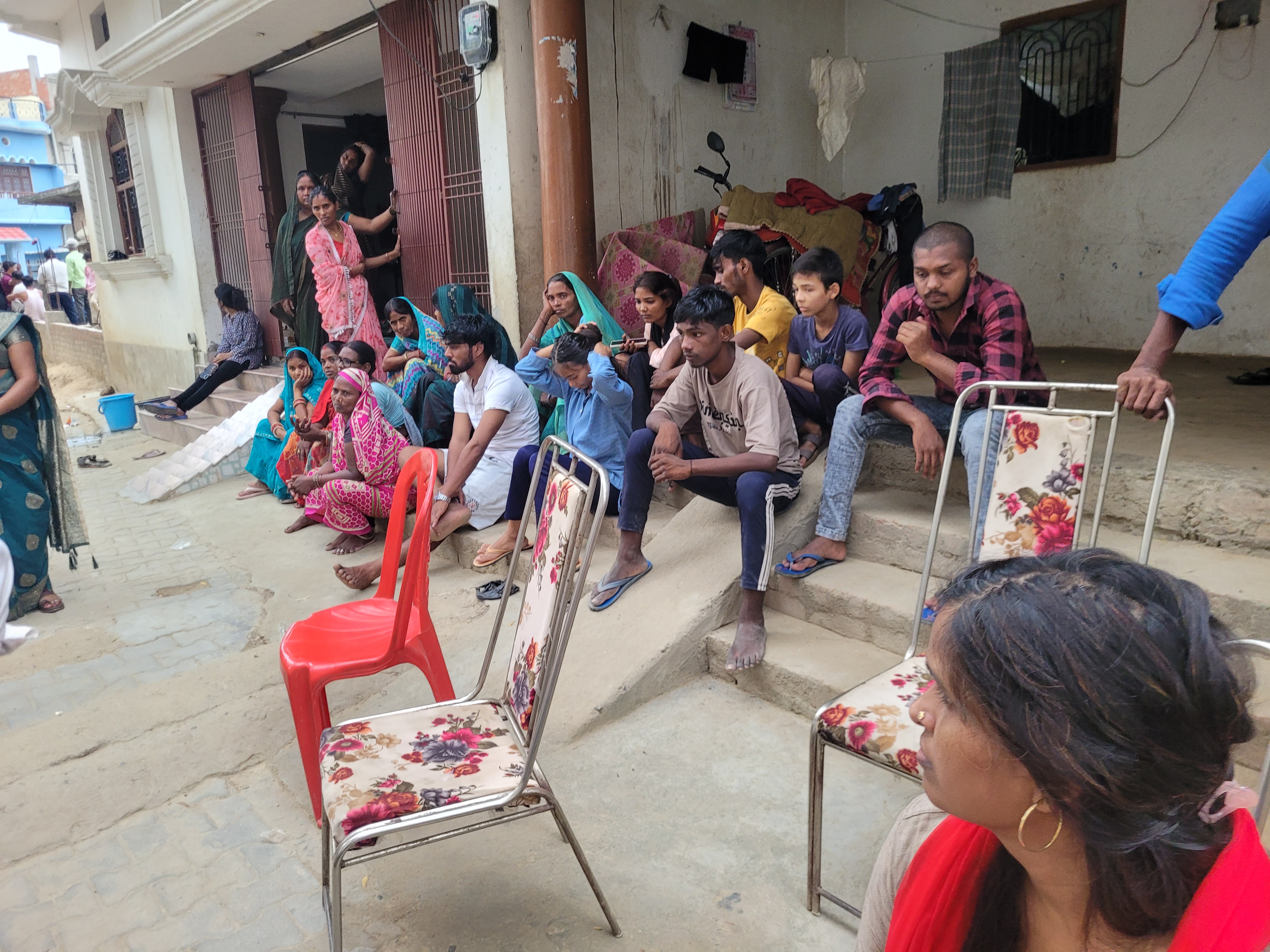 आजमगढ़ में मृतक दुर्गेश के घर के बाहर बैठी महिलाएं और लोग।