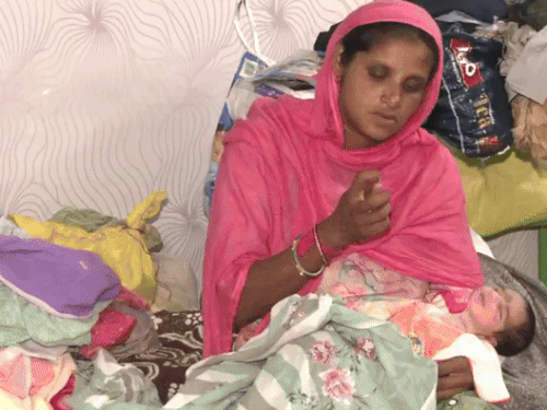 फाजिल्का में स्कूल में बनाए गए रेस्क्यू सेंटर में बच्चे के साथ महिला। - Dainik Bhaskar