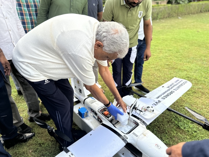 Agriculture Minister Kirori Lal Meena putting 1.5 kg of chemicals required to rain in the box made in the drone.