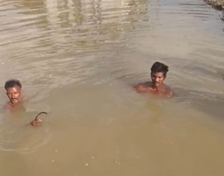पाली जिले के सिरियारी में नाडी में डूबे बच्चे की तलाश करते गोतोखोर।