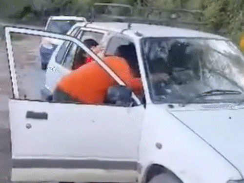 पुलिस के रोकने के बाद गाड़ी चला रही नाबालिग को बाहर उतारते हुए व्यक्ति।