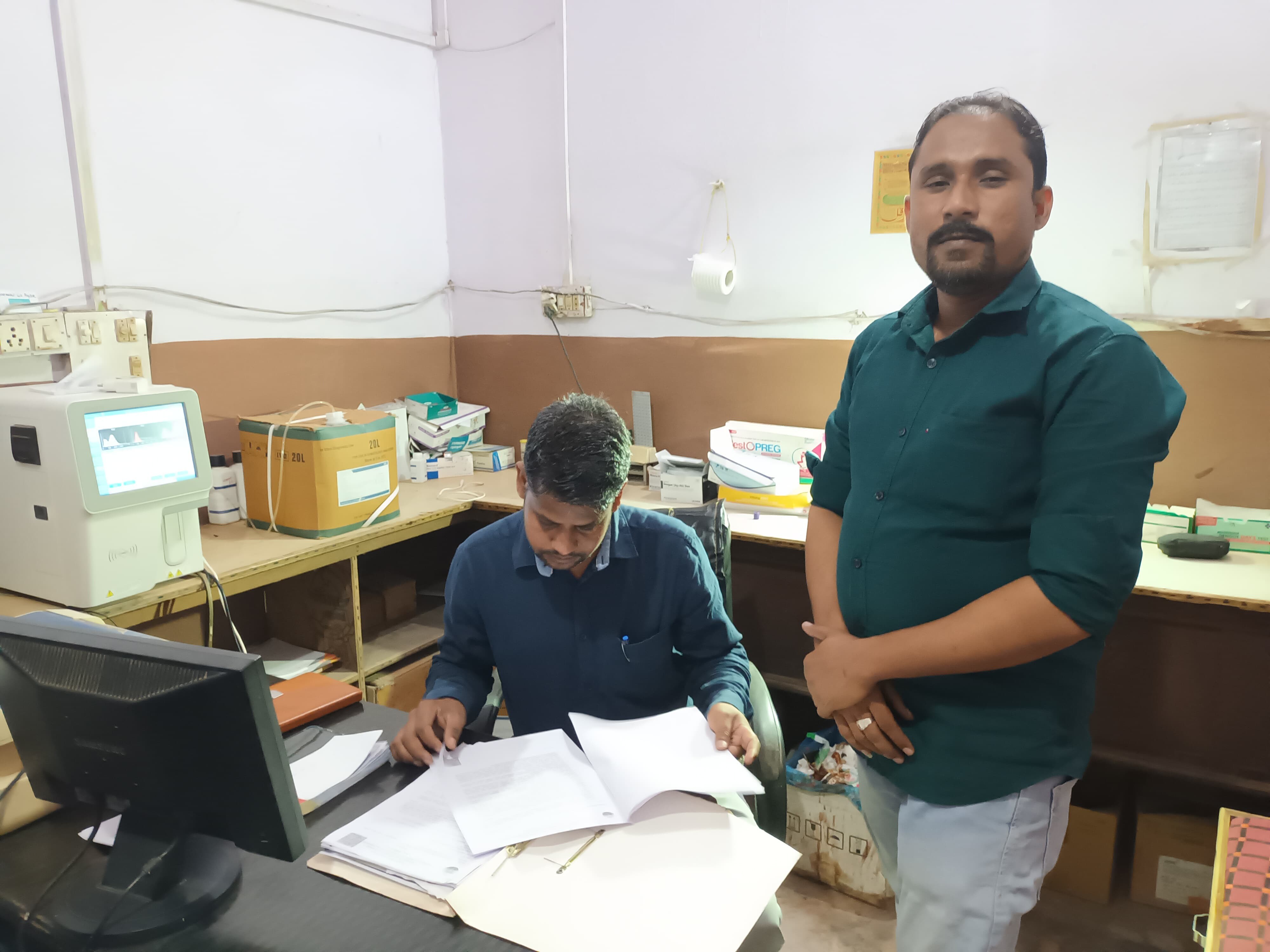 लैब के दस्तावेजों की जांच करते स्वास्थ्य विभाग की टीम के सदस्य।