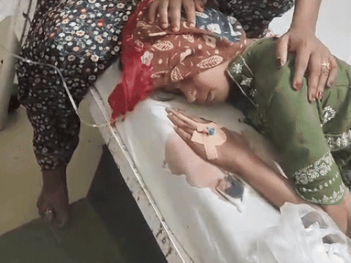 बच्ची के कटे कान को पॉलिथीन में डालता कर्मचारी।