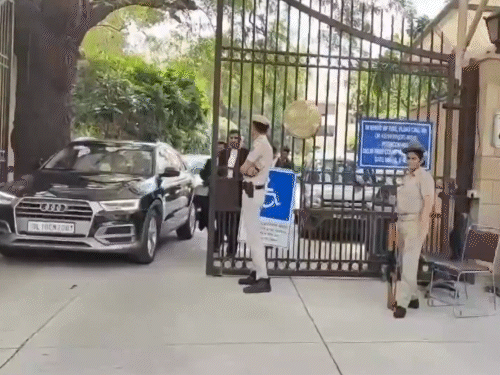 कोर्ट कैंपस के बाहर आती गाड़ियां और वकील।