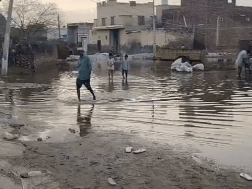 Youth and child passing through waterlogging in village sugar Mandori.