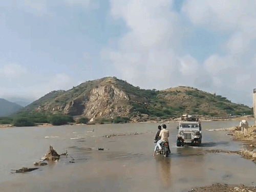 उम्मेदपुर से नदी को पार करते बाइक और कार सवार।