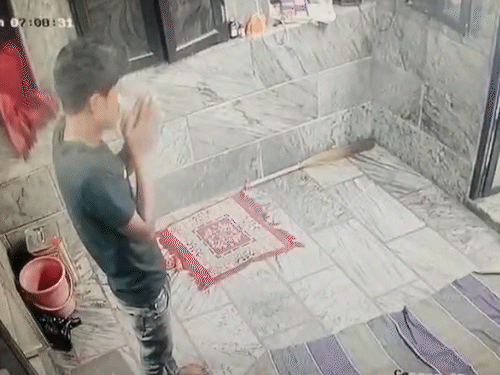 मंदिर में हाथ जोड़कर प्रार्थना करता चोर। इस दौरान चोर की निगाह सीसीटीवी की ओर भी गई।