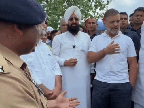 पुलिस और प्रशासन के अधिकारियों से बात करते राहुल गांधी।