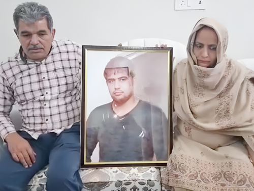 His parents holding the picture of the deceased Sagar Dhankhar in their hands.