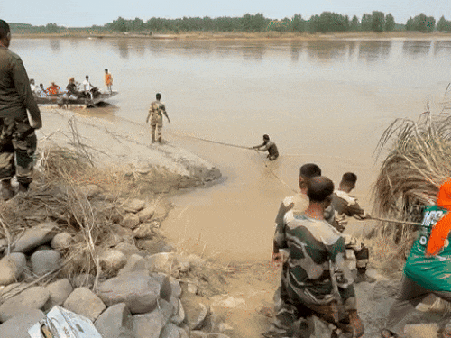Army soldiers pulling the boat from the river Makauda on the river Makauda.