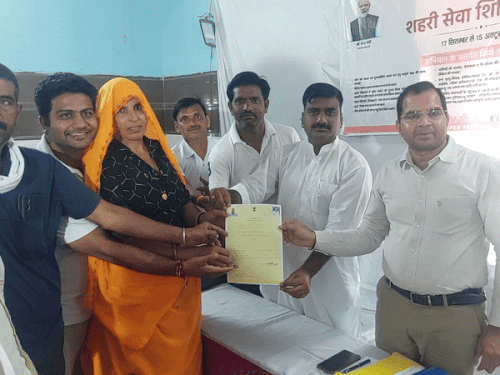दौसा नगर परिषद कमिश्नर ने पट्टे वितरित किए, साथ में शहर भाजपा अध्यक्ष भूपेंद्र सिंह।