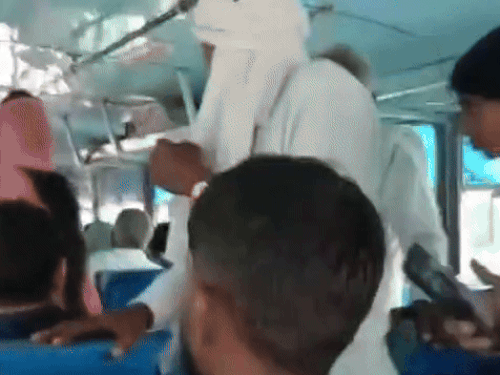 कार के आगे निकलते ही उसे देखते हुए बस में सवार यात्री।