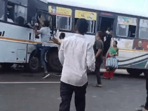 घायल निजी बस ड्राइवर को बस से बाहर निकालते हुए लोग।