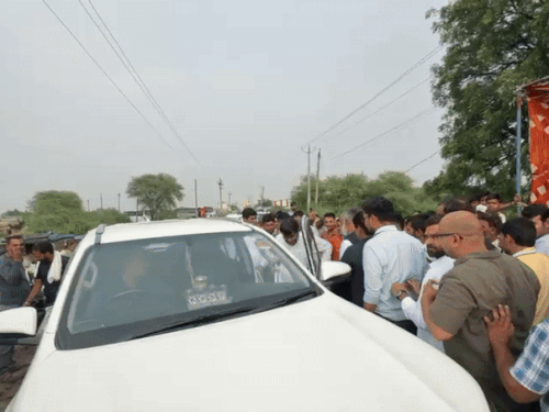 Minister sitting in the car and leaving the protest site.