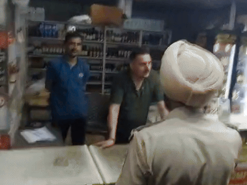 लुधियाना में शराब ठेके के करिंदे को चेतावनी देते सब-इंस्पेक्टर सुलख्न सिंह।