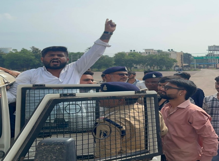 प्रदेश महासचिव भावेश शुक्ला को हिरासत में लेते हुए पुलिस अधिकारी।