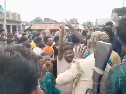 The police have kept the young man in the community hall. This angry mob is demonstrating to take him out.