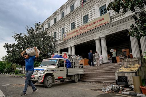 काठमांडू में सिंह दरबार परिसर में प्रधानमंत्री कार्यालय से बची हुई फाइलों को नए कार्यालय में ले जाते हुए कर्मचारी।