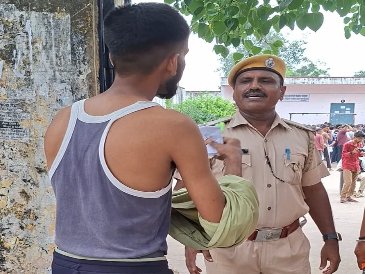अभ्यर्थी से फुल बाजू की टी-शर्ट उतरवाते पुलिसकर्मी