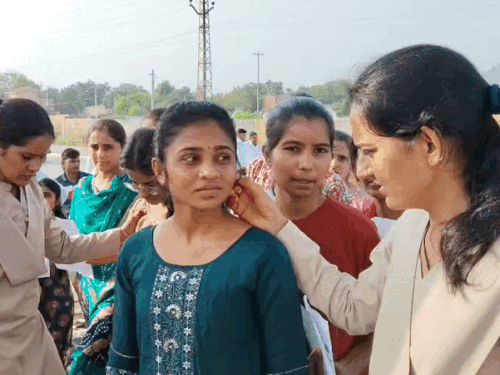 महिला अभ्यर्थियों के कानों की बालिया चेक करते हुए पुलिस।