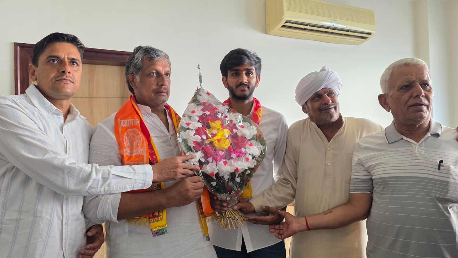 डूसू अध्यक्ष आर्यन मान को बुके भेंट करते खाप प्रधान।