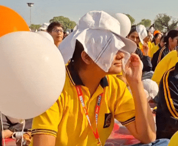 धूप से बचाव के लिए टोपी और कपड़ा लगाए हुए छात्रा।